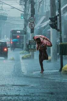 Pessoas com guarda chuva a tentar proteger-se do mau tempo